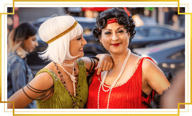 Two women dressed in Roaring 20s flapper dresses