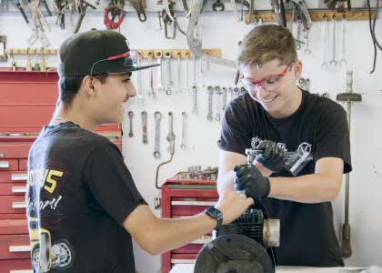 San Diego Automotive Museum's IGNITE Academy featuring 2 students working on car parts
