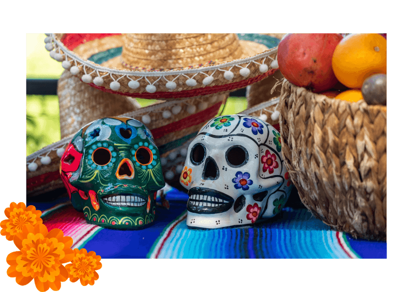 Two sugar candy skulls sitting on a blanketed table at a Día de los Muertos Celebration